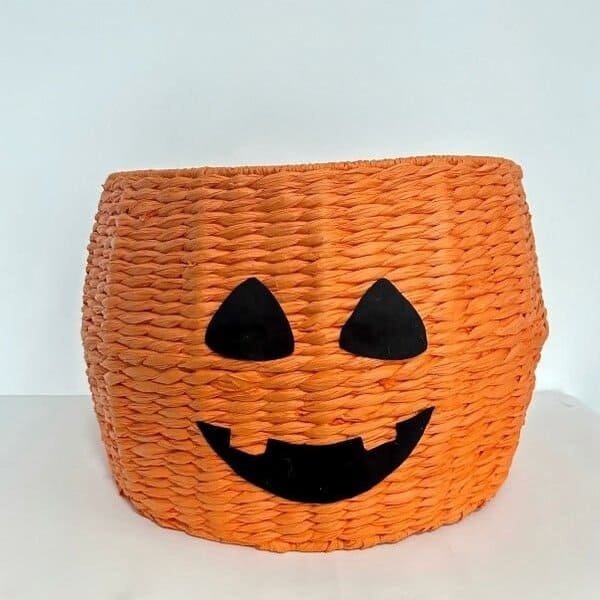 Halloween-themed woven storage basket with pumpkin face