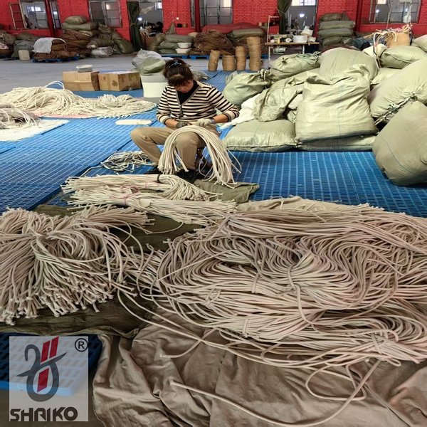 Worker handling cotton ropes in workshop